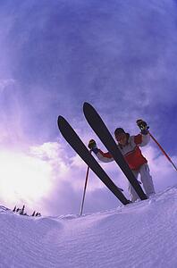 Skier on edge of slope viewed from underneath