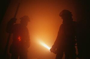 Firemen in smoky room with flashlight