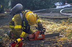 Fireman starting chainsaw