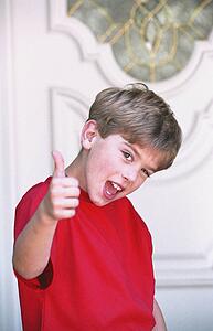 Boy with thumbs-up in front of door