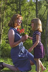 Mother and daughter with flowers in park
