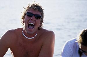 Man with shell necklace at lake