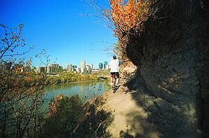 Man cycling on path beside river