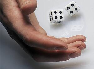 Hand rolling dice on white surface