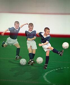 Multiple exposure of boy kicking soccer ball
