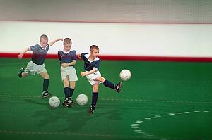 Multiple exposure of boy kicking soccer ball