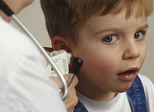 Boy getting ear examined by doctor