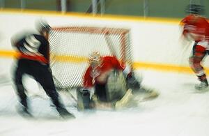 Ice hockey player shooting puck at goal