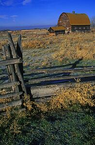 Wooden fence with old barn in background