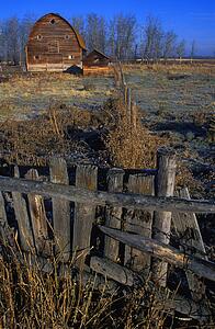 Wooden fence with old barn in background