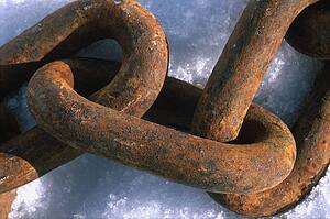 Rusted heavy chain link on snow