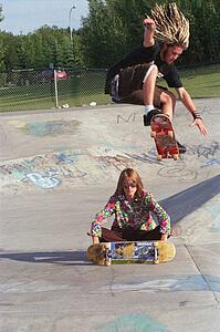 Boarders performing stunt at skate park
