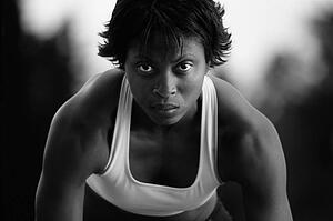 Black and white of woman at sprinter's starting blocks