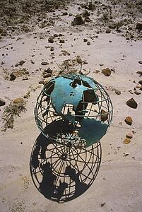 Wire globe outside on sand