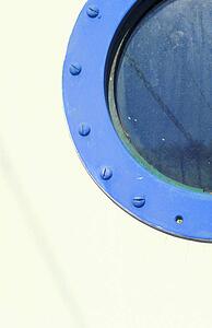Porthole on blue and white boat