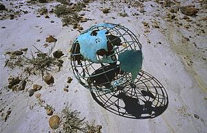 Wire globe outside on sand