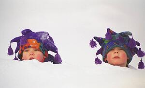 Two toddlers buried up to their necks in snow