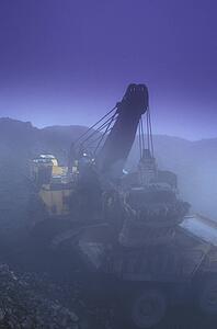 Drag line dumping bucket into ore truck