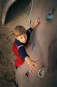 Young boy ascending climbing wall