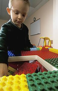 Young boy playing with large Lego blocks