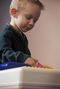 Young boy playing with large Lego blocks