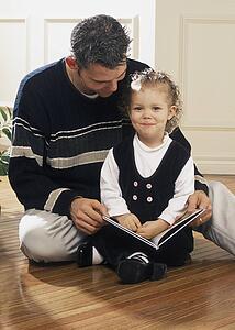 Father reading a book with daughter
