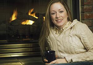 Young woman in front of fireplace