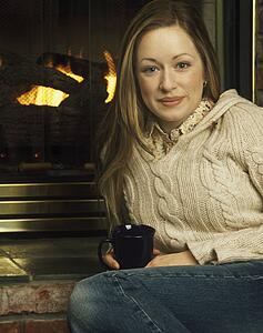 Young woman in front of fireplace