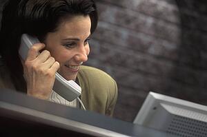 Businesswoman on the phone in front of computer