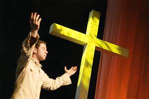 Man worshipping beside cross