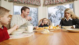 Family smiles at breakfast table