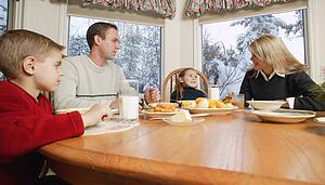 Family smiles at breakfast table