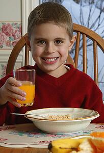 Young boy with food at breakfast table