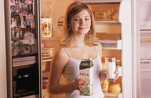 Teenager getting milk from fridge