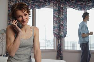Wife chats on phone while husband waits