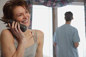 Wife chats on phone while husband waits