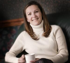 Woman smiles with cup of coffee