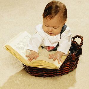 Baby reading a book in a basket