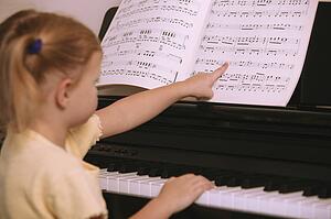 Child learns to play the piano