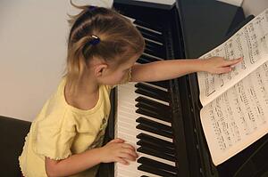 Child learns to play the piano