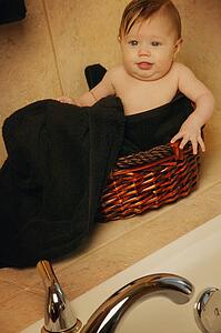 Baby sitting in bathroom basket