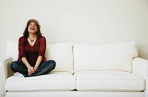 Laughing woman sitting on sofa