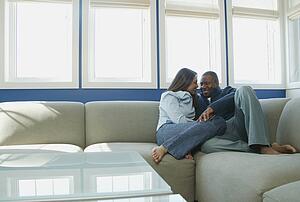 Couple snuggles on sofa