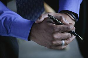 A businessman holds a pen