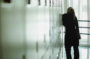 Student peers down hallway
