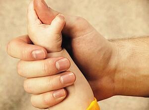 Baby's hand holds on