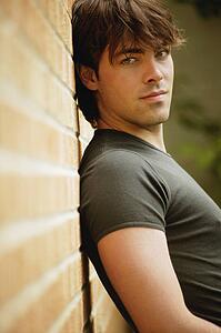 Man leans against brick wall