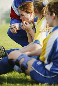 Soccer players sit on grass