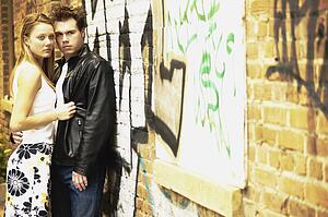 Couple standing by graffiti wall