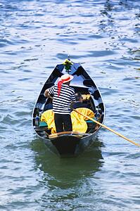 Gondolier navigating the canal of Venice Italy Europe